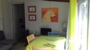 ein Zimmer mit einem Tisch und einem Pferdegemälde an der Wand in der Unterkunft Les grands pins in Saint-Andiol