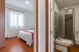 y baño con cama, ducha y aseo. en Apartamentos Cuna 41, en Sevilla