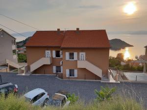 a house with two cars parked in a parking lot at Slavica apartments 2 in Sveti Juraj +11 photos