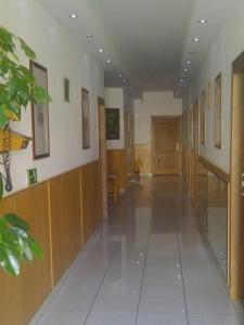 - un couloir dans un bâtiment doté de parquet et d'une porte dans l'établissement Rézkakas Fogadó, à Zirc