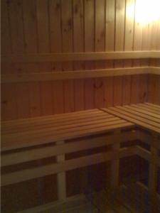 a wooden bench in a room with wooden walls at Rézkakas Fogadó in Zirc