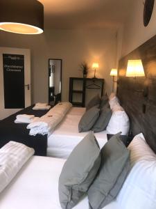 ein Schlafzimmer mit 3 Betten und Kissen darauf in der Unterkunft Hamburg Apart in Hamburg