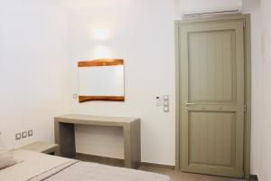 a bedroom with a bed and a table and a mirror at Aeris in Koufonisia