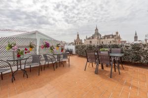 a patio with tables and chairs on a roof at Apartamentos Cuna 41 in Seville