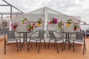 a patio area with chairs, tables, and plants at Apartamentos Cuna 41 in Seville