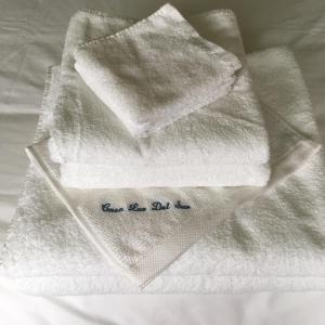 uma pilha de toalhas brancas sentadas numa cama em B&B Casa Luz del Sur, adults only em Alhaurín el Grande