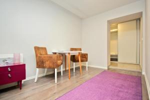 una stanza con un tavolo e due sedie e un tappeto viola di Apartman Amaya a Sarajevo