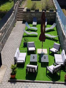 OHH - Porto Boutique Guest House في بورتو: مجموعة من الكراسي والطاولات ومظلة على العشب