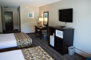 a hotel room with a bed and a flat screen tv at Sea to Sky Hotel and Conference Centre in Squamish