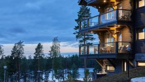 a house with a balcony overlooking a lake at Naava Chalet First Floor in Ähtäri +9 photos