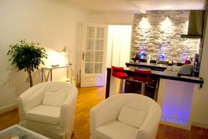 two white chairs in a living room with a counter at L'Erdream in Nantes