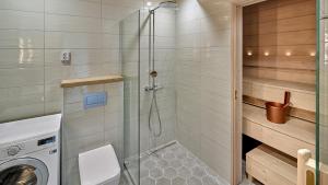 a bathroom with a shower and a washing machine at Naava Chalet First Floor in Ähtäri