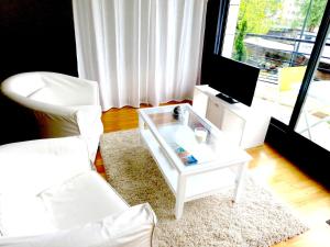 a living room with a white coffee table and a white chair at L'Erdream in Nantes