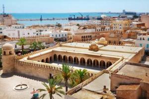 Una vista de una ciudad con edificios y palmeras. en Superbe Appartement bord de mer, en Sousse