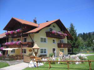 ein großes Haus mit Blumen davor in der Unterkunft Apart Wehrmeister in Jungholz