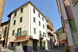 un edificio bianco con persiane verdi su una strada di il ricamo a Badalucco