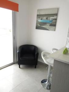 a living room with a black chair and a table at Elenapa Holiday Apartments in Ayia Napa
