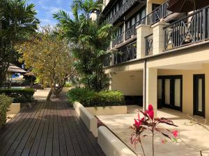 a walkway next to a building with palm trees at Brownes Condominium 1 in Bridgetown