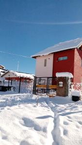 uma casa com neve no chão em frente dela em Departamentos de Alquiler Turistico: Familia Eguren em San Carlos de Bariloche