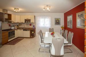 Apartment Marijeta في سبليت: مطبخ وغرفة طعام مع طاولة وكراسي بيضاء