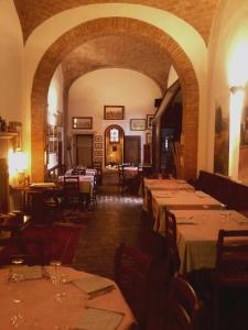 カスティリオーネ・ドルチャにあるCisterna Nel Borgoの建物内のダイニングルーム(テーブル、椅子付)