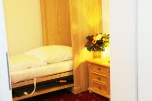 a bedroom with a bed and a dresser and a mirror at Landhotel Rangau Gasthof & Brennerei in Markt Erlbach