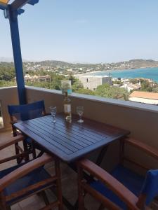 a wooden table with two wine glasses on a balcony at Evangelia in Karfas