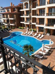 une piscine extérieure avec des chaises et un bâtiment dans l'établissement Boulevard Sea Residence, à Sunny Beach