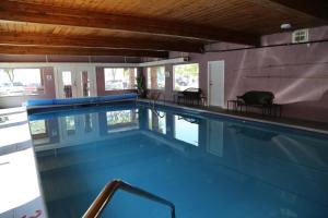 ein Schwimmbad mit blauem Wasser in einem Gebäude in der Unterkunft SlumberLodge Hotel in Penticton