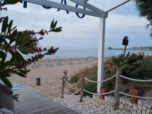 a beach with chairs and the ocean in the background at Villaggio Camping Oasi in Vieste