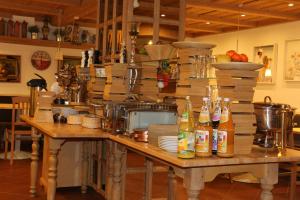 a kitchen with a wooden table with bottles on it at Landhotel Rangau Gasthof & Brennerei in Markt Erlbach