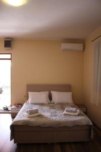 a bedroom with a large bed with two towels on it at Studio apartman Ana in Šibenik