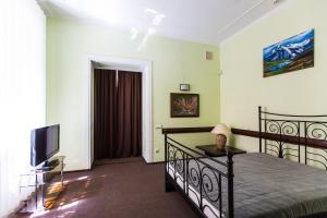a bedroom with a bed and a flat screen tv at Luxury central two bedroom apartment in Lviv