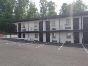 a large white building with a parking lot at Penn Lodge Hotel & Suites Philadelphia - Bensalem in Bensalem