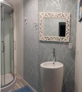 a bathroom with a sink and a mirror on the wall at Pause Campagne - Chambres d'Hôtes in Pouy-de-Touges