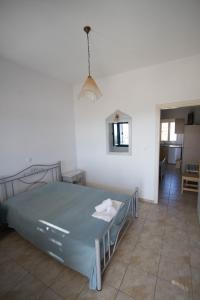 1 dormitorio con 1 cama en una habitación con pasillo en Helena's Apartments en Manganari