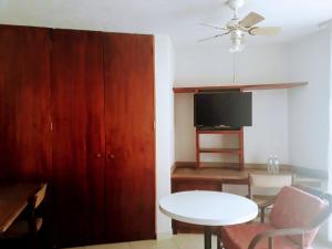 a living room with a white table and a tv at Hotel Del Parque in Tequisquiapan