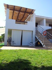 a white house with stairs and a grass yard at Casa Relax in Siniscola