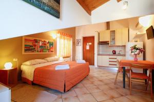 ein Schlafzimmer mit einem Bett und einem Tisch sowie eine Küche in der Unterkunft B&B Dimora Morelli in Gubbio