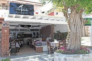 a restaurant with tables and chairs and a tree at Marine House Andrianna -Adults only in Siviri