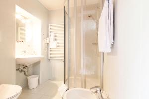 uma casa de banho com um chuveiro, um WC e um lavatório. em Hotel Messnerwirt em Anterselva di Mezzo