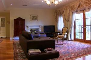 sala de estar con sofá y TV en The Residence at Barossa Chateau, en Lyndoch