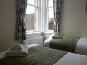 Un pat sau paturi într-o cameră la Crail House Apartments