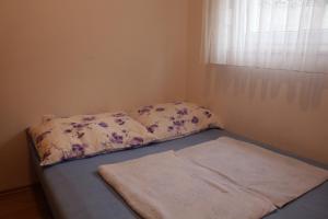 Bett in einem Zimmer mit Kissen und Fenster in der Unterkunft Mia 5 in Crikvenica