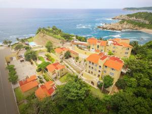 a group of houses with orange roofs and the ocean at Villas & Resort Luz de Luna in Santa Cruz Huatulco