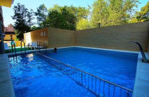 a large blue swimming pool with a brick wall at Hotel LeMan in Kabardinka