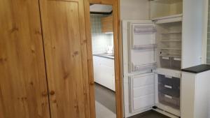 a small kitchen with an empty refrigerator and a door at Cozy home in between Malmö & Lund in Åkarp +3 photos