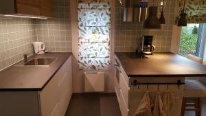 a small kitchen with a sink and a window at Cozy home in between Malmö & Lund in Åkarp