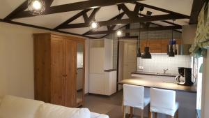 a kitchen with white chairs and a counter top at Cozy home in between Malmö & Lund in Åkarp