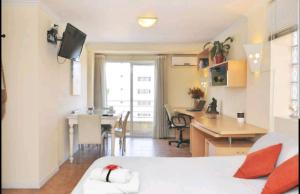 Pokój z łóżkiem, biurkiem i kuchnią w obiekcie Temporary Rental Apartments w Córdobie